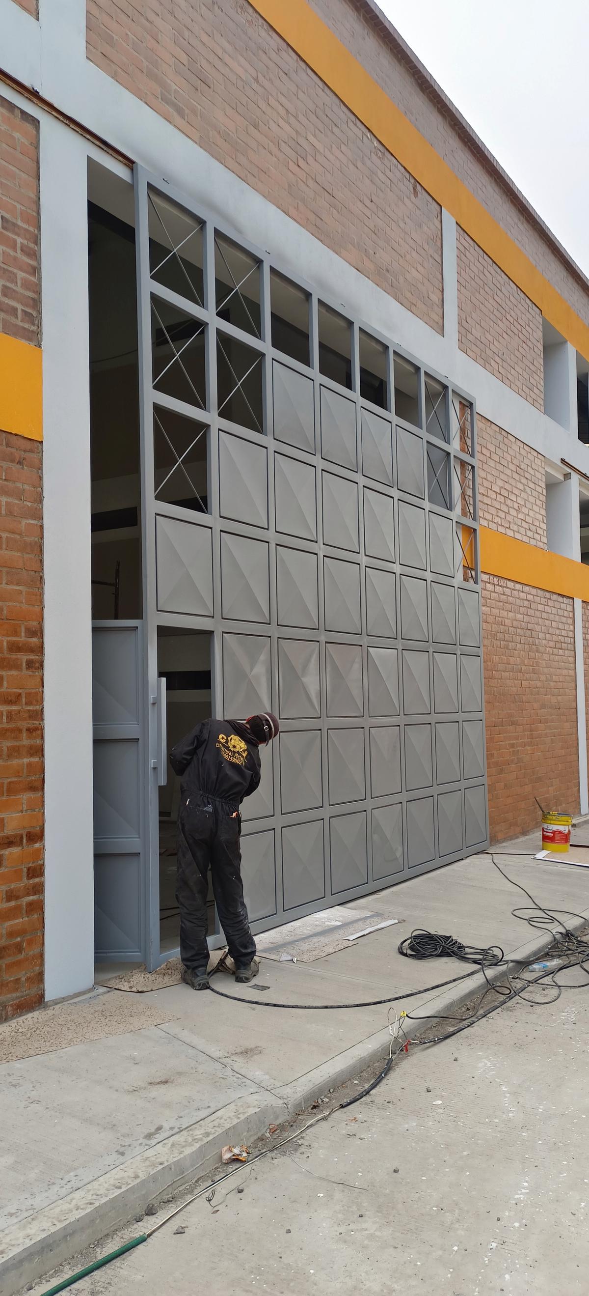 Trabajador instalando portón metálico